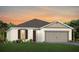 One-story home with two-car garage, neutral siding, and landscaping at 2705 Serenity Meadow Dr, Kissimmee, FL 34744