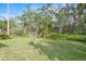 Backyard features beautiful trees, a large grassy area and a small palm at 293 Saxony Ct, Winter Springs, FL 32708