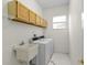 Functional laundry room with a sink, cabinetry, and window, offering practical amenities at 293 Saxony Ct, Winter Springs, FL 32708