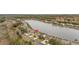Aerial view of homes on a lake with manicured lawns, and beautiful, mature landscaping at 2983 Sunset Vista Blvd, Kissimmee, FL 34747