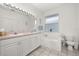 Bright bathroom featuring a double vanity, soaking tub, and white tile flooring at 2983 Sunset Vista Blvd, Kissimmee, FL 34747