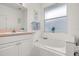 Bathroom with single vanity, soaking tub, and tiled walls at 2983 Sunset Vista Blvd, Kissimmee, FL 34747