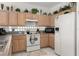 Kitchen with wood cabinets, white appliances, and tile floors at 2983 Sunset Vista Blvd, Kissimmee, FL 34747