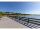 Community lake view featuring a wooden fence and neighborhood homes in the background at 2983 Sunset Vista Blvd, Kissimmee, FL 34747