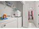 Efficient laundry room with washer, dryer, and overhead storage, leading to another room at 2983 Sunset Vista Blvd, Kissimmee, FL 34747