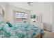 Bright main bedroom with tropical bedding, ceiling fan, and sliding doors to the lanai at 2983 Sunset Vista Blvd, Kissimmee, FL 34747