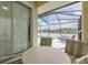 Screened patio with lake view, table and chairs, and access to pool at 2983 Sunset Vista Blvd, Kissimmee, FL 34747