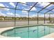 Relaxing screened-in pool with lake view and striped lounge chairs, perfect for outdoor enjoyment at 2983 Sunset Vista Blvd, Kissimmee, FL 34747