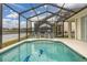 Inviting screened-in pool area with lounge chairs and a picturesque view of the adjacent lake at 2983 Sunset Vista Blvd, Kissimmee, FL 34747