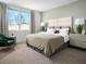 Spacious main bedroom with king-size bed, soft green color scheme, and ample natural light at 321 Castle Dr, Lake Alfred, FL 33850