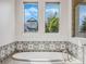 Bathroom featuring a freestanding oval bathtub and two windows at 32117 Red Tail Blvd, Sorrento, FL 32776