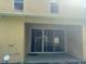 A covered back patio featuring sliding glass doors, a Ring security system and a neutral colored exterior at 3213 Holderness Dr, Kissimmee, FL 34741