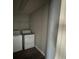 Small laundry room with basic washer and dryer units, overhead shelf for storage and neutral walls at 3213 Holderness Dr, Kissimmee, FL 34741