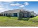 Exterior of home with a screened in patio and a lush green lawn at 3525 Belland Cir # A, Clermont, FL 34711