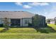 Beautiful backyard featuring a screened-in lanai and lush green lawn, perfect for outdoor living and entertaining at 3525 Belland Cir # A, Clermont, FL 34711