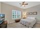 Cozy bedroom features plantation shutters, a ceiling fan, and a comfortable bed with decorative pillows at 3525 Belland Cir # A, Clermont, FL 34711