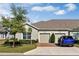 Attractive home featuring a two-car garage, brick driveway, mature trees, and neatly trimmed landscaping at 3525 Belland Cir # A, Clermont, FL 34711