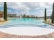 Large community swimming pool with sun deck, palm trees, and a clear blue sky overhead at 3525 Belland Cir # A, Clermont, FL 34711