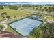 Aerial view of the community tennis courts with blue and green surfaces and manicured landscaping at 3525 Belland Cir # A, Clermont, FL 34711