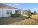 Backyard featuring a lush green lawn, manicured hedges, and a peek at the screened-in lanai at 3541 Belland Cir # A, Clermont, FL 34711