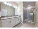 Bathroom featuring a double sink vanity, a large mirror, a glass enclosed shower, and tile flooring at 3541 Belland Cir # A, Clermont, FL 34711