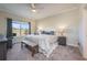 Spacious bedroom featuring a ceiling fan, gray nightstands, carpet, and a bench at the end of the bed at 3541 Belland Cir # A, Clermont, FL 34711