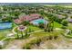 Aerial view of a community center with a large pool, tennis courts, and lush landscaping at 3541 Belland Cir # A, Clermont, FL 34711