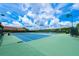 Outdoor tennis courts with blue playing surface, green perimeter, and bright overhead lighting at 3541 Belland Cir # A, Clermont, FL 34711