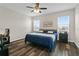 Bright bedroom featuring a queen-size bed, wood floors, and sunlit windows with blinds at 3610 Charmed Ln, St Cloud, FL 34772