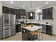 Modern kitchen featuring stainless steel appliances, a central island, and dark cabinetry at 3610 Charmed Ln, St Cloud, FL 34772