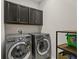 Well-equipped laundry room featuring modern, front-loading washer and dryer, and cabinetry for storage at 3610 Charmed Ln, St Cloud, FL 34772