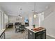 Open-concept living room with a kitchen island, dining table and staircase leading upstairs at 3610 Charmed Ln, St Cloud, FL 34772