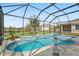Inviting screened-in pool featuring a waterfall, hot tub, and lush landscaping, perfect for relaxation and entertainment at 3610 Charmed Ln, St Cloud, FL 34772