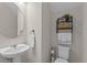 A well-lit powder room featuring a pedestal sink and elegant decorative shelving at 3610 Charmed Ln, St Cloud, FL 34772