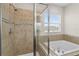 Bathroom showcasing a tiled shower with glass door and a separate soaking tub with chrome fixtures at 3610 Charmed Ln, St Cloud, FL 34772