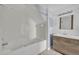 A full bathroom with a bathtub, vanity, light fixtures, and tiled walls at 4004 Santa Maria Dr # 105, Kissimmee, FL 34741