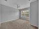 Spacious bedroom featuring neutral-toned walls, carpet floors, a ceiling fan, and bright windows at 4004 Santa Maria Dr # 105, Kissimmee, FL 34741