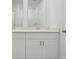 Modern bathroom with dual sinks, white cabinets and a well lit mirror at 4026 Copperleaf Ln, Poinciana, FL 34759