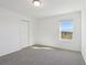Carpeted bedroom with closet and exterior view at 4026 Copperleaf Ln, Poinciana, FL 34759
