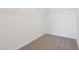 Walk-in closet with beige carpet, white walls, and a metal shelf at 4026 Copperleaf Ln, Poinciana, FL 34759
