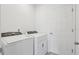 Well-lit laundry room featuring modern washer and dryer units with a door to a different room at 4026 Copperleaf Ln, Poinciana, FL 34759