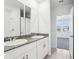 This bright bathroom features double sinks with granite countertops and a view to a bedroom at 4031 Cooperleaf Ln, Poinciana, FL 34759