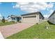 Charming single-Gathering home featuring a brick driveway, two car garage and manicured lawn at 4031 Cooperleaf Ln, Poinciana, FL 34759