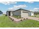Charming single-Gathering home featuring a brick walkway, two car garage and well-maintained lawn at 4031 Cooperleaf Ln, Poinciana, FL 34759
