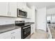 Well-equipped kitchen boasts stainless steel appliances and ample granite countertop space at 4031 Cooperleaf Ln, Poinciana, FL 34759