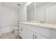 Modern bathroom with double vanity, white cabinets and tiled shower at 4034 Copperleaf Ln, Poinciana, FL 34759