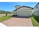 Beautiful two-story home featuring a two-car garage, brick driveway and a neatly maintained lawn at 4034 Copperleaf Ln, Poinciana, FL 34759
