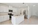 Bright open-concept kitchen features white cabinets, stainless appliances, and kitchen island at 4034 Copperleaf Ln, Poinciana, FL 34759