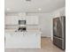 Bright kitchen features white cabinetry, an island, and stainless steel appliances at 4034 Copperleaf Ln, Poinciana, FL 34759