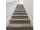 Carpeted staircase with white walls, leading to the upper level at 4034 Copperleaf Ln, Poinciana, FL 34759